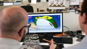 Projetista utilizando software CAD em estação de trabalho para desenhar um componente técnico