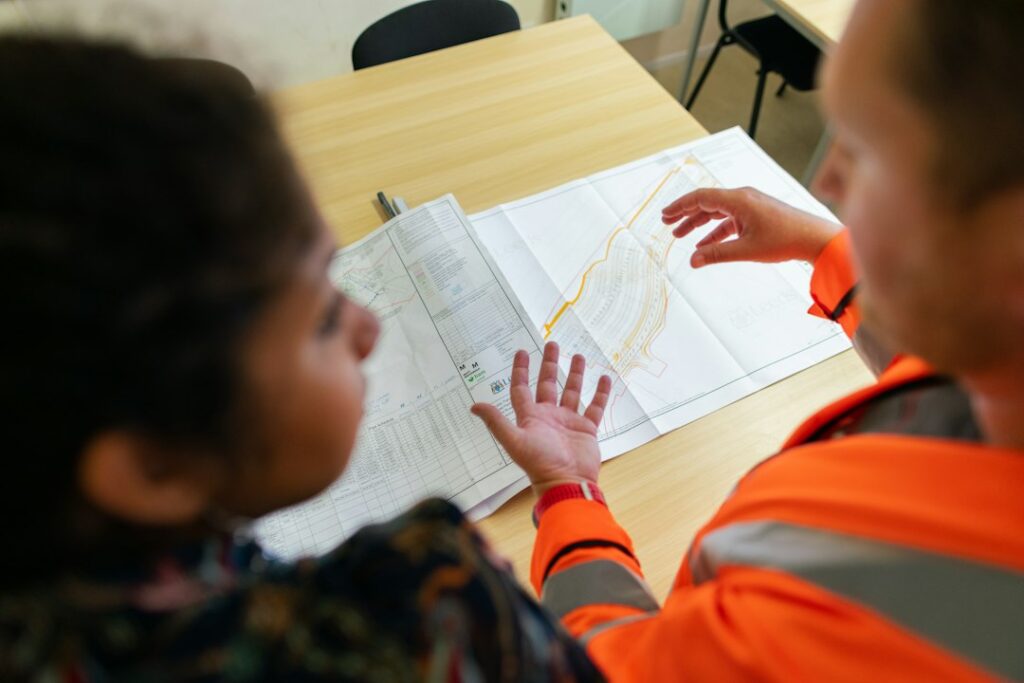 Profissionais de engenharia discutindo documentos de projeto em equipe